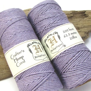 May include: Two spools of lavender purple hemp cord, each with a label that reads "Hemptique" and "Crafter's Hemp Cord". One label also reads "205 feet, 62.5 meter, 20 lbs".