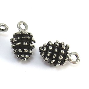 May include: Six silver-toned pine cone charms with a loop for hanging. The pine cones are detailed and realistic.