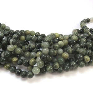 May include: A strand of green and white gemstone beads. The beads are round and have a smooth, polished finish.
