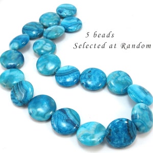 Puede incluir: Una hebra de 17 cuentas de ágata azul turquesa, cada una con un patrón único de remolino. Las cuentas son redondas y planas, y están enhebradas en un hilo transparente. El texto "5 beads Selected at Random" es visible en la imagen.