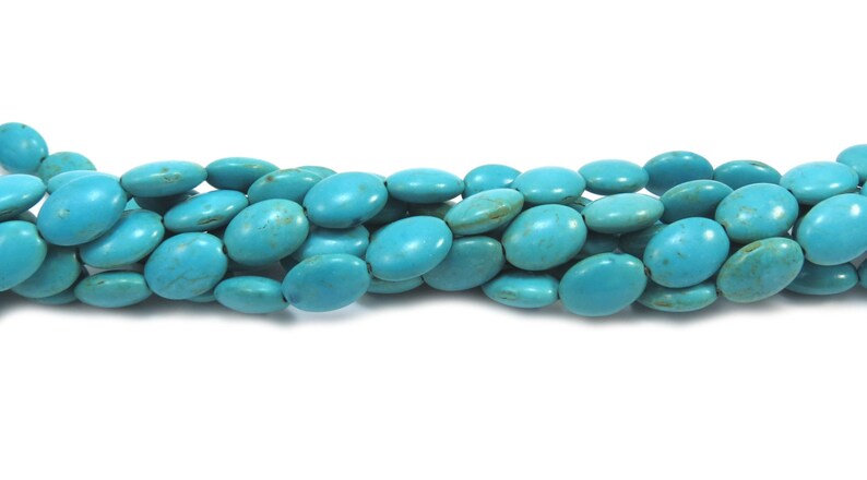 May include: A strand of turquoise oval beads. The beads are a bright, vibrant blue color and have a smooth, polished finish.