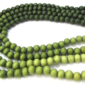Peut inclure: Un brin de perles en bois vert avec un d&eacute;grad&eacute; de vert fonc&eacute; &agrave; vert clair.
