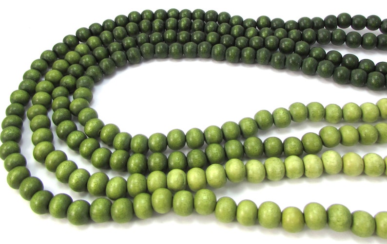 Peut inclure: Un brin de perles en bois vert avec un d&eacute;grad&eacute; de vert fonc&eacute; &agrave; vert clair.