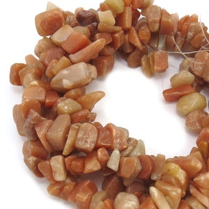 May include: A strand of orange, brown, and yellow gemstone chips. The chips are irregular in shape and have a natural, rough texture.