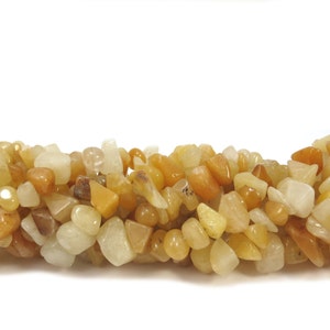 May include: A strand of yellow and white gemstone chips. The chips are irregular in shape and size, and have a smooth, polished finish.