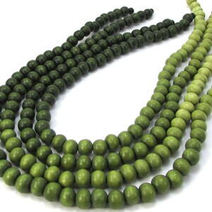Peut inclure: Un brin de perles en bois vert avec un d&eacute;grad&eacute; de vert fonc&eacute; &agrave; vert clair.