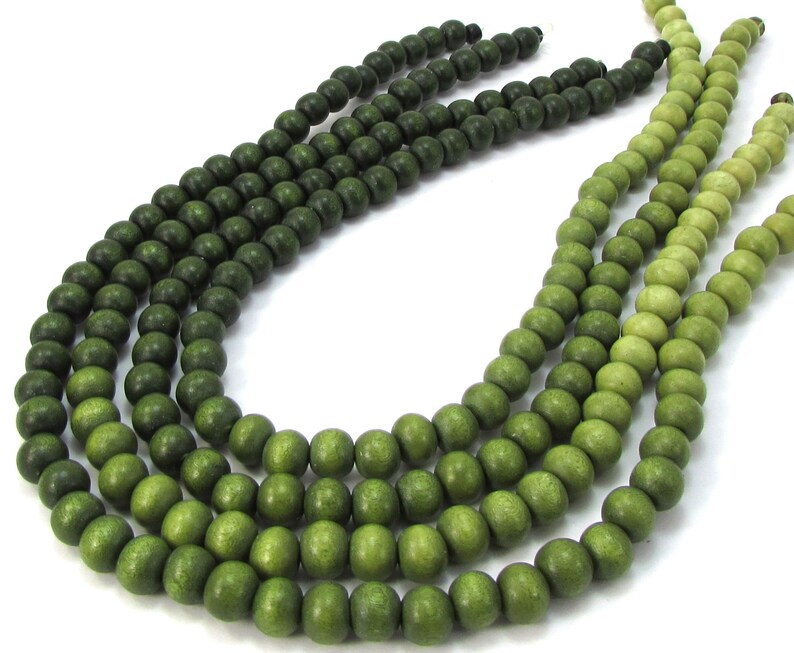 Peut inclure: Un brin de perles en bois vert avec un d&eacute;grad&eacute; de vert fonc&eacute; &agrave; vert clair.