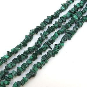Puede incluir: Una hebra de cuentas de chip de malaquita verde. Las cuentas son irregulares en forma y tamaño, y tienen una textura natural y rugosa.