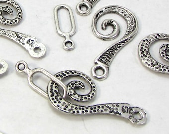 May include: Silver tone metal jewelry findings with a spiral design. The findings have a textured surface and a loop on one end.