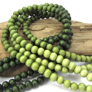 Peut inclure: Un brin de perles en bois dans des tons de vert, les perles passant progressivement du vert fonc&eacute; au vert clair.
