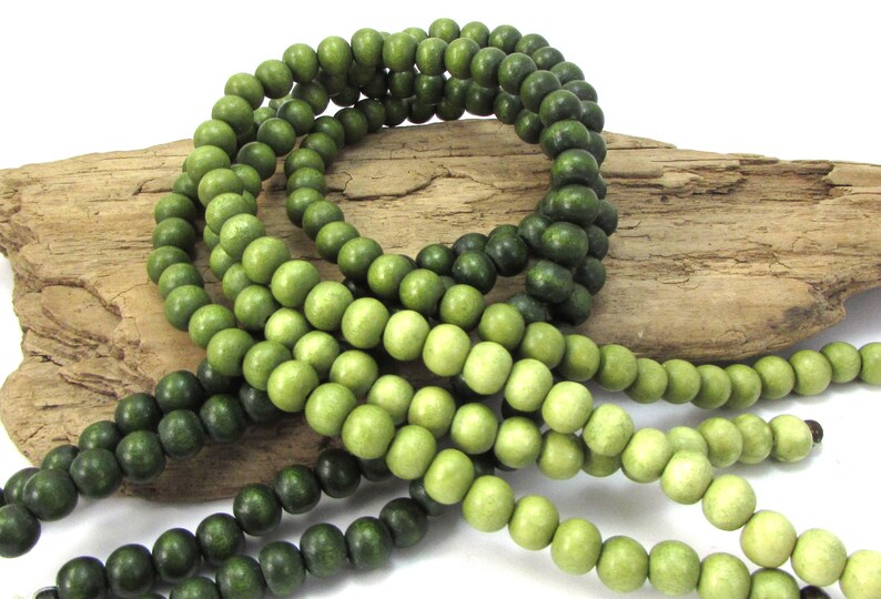 Peut inclure: Un brin de perles en bois dans des tons de vert, les perles passant progressivement du vert fonc&eacute; au vert clair.