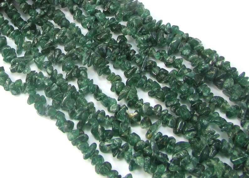 May include: A strand of green gemstone chips, also known as green aventurine, for jewellery making. The chips are irregular in shape and have a translucent appearance.