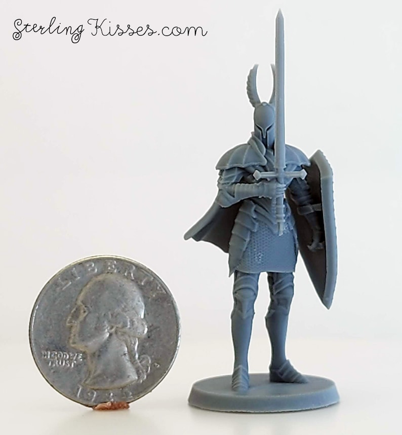 May include: A gray plastic miniature figure of a knight wearing armor and holding a sword and shield. The knight is standing on a round base. The figure is about the size of a US quarter.