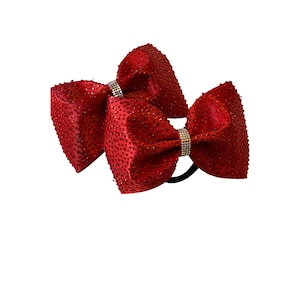 May include: Two red satin bows with rhinestones and a black elastic headband.
