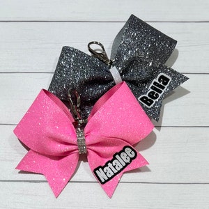 Personalized Cheer Bow Key Chain with Outlined Name on Tail only, ALL COLORS available. Measures 4x3”.