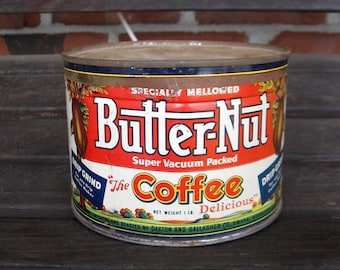 May include: Vintage Butter-Nut coffee can with a red, white, and blue label. The can features the text "Butter-Nut" in large white letters, with "The Coffee Delicious" below. The net weight is 1 lb.