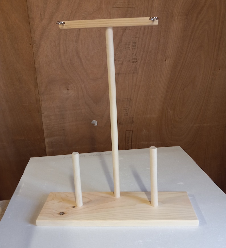 May include: Wooden stand with three dowels, designed for displaying items like jewelry or scarves.