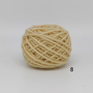 May include: A ball of light beige yarn, tightly wound with visible texture. The yarn is a neutral colour, suitable for various crafting projects. The number "8" is printed in black on the bottom right of the image.