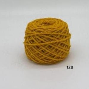 May include: A ball of mustard yellow yarn, tightly wound, with visible texture. The yarn is a solid colour, and the number "128" is printed on the lower right corner. The yarn appears to be made of wool or a similar fibre.