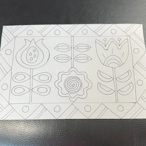 Peut inclure: Un dessin au trait noir et blanc de trois fleurs stylisées avec des feuilles. Les fleurs sont dans un cadre carré avec un motif géométrique.