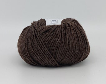 May include: A ball of brown yarn with a white label that says "Woolmark" on it.