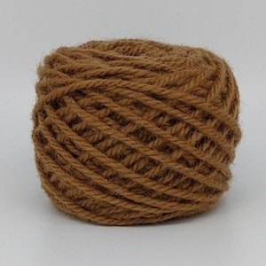 Peut inclure: Une pelote de laine brune, enroulée en une bobine serrée.