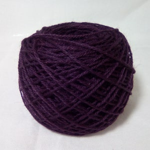 May include: A ball of deep purple yarn, ready for knitting or crocheting.