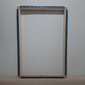 Peut inclure: Un cadre en bois avec une bordure bleue, prêt pour une toile.