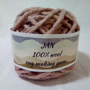 May include: A ball of light brown rug making yarn labeled "JAN 100% wool rug making yarn".
