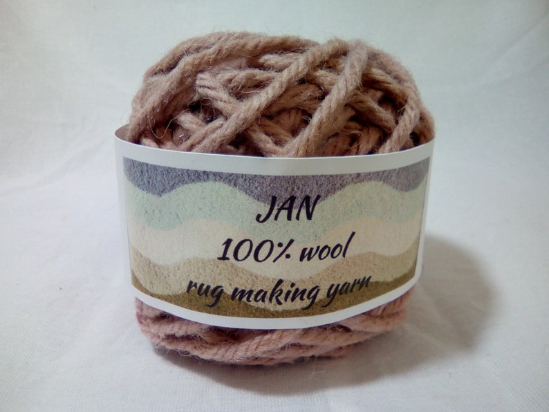 May include: A ball of light brown rug making yarn labeled "JAN 100% wool rug making yarn".