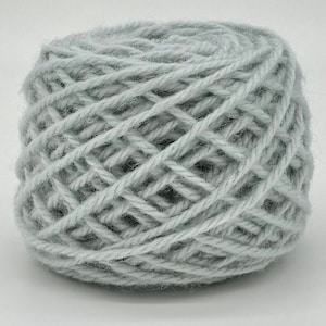 Peut inclure: Une pelote de fil de couleur gris clair, enroulée en forme de boule.