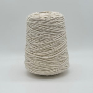 May include: A cone of natural white yarn.