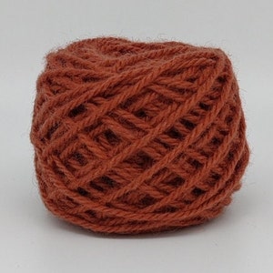 May include: A ball of rust-colored yarn, perfect for knitting or crocheting.
