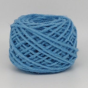 Peut inclure: Une pelote de laine bleu clair.