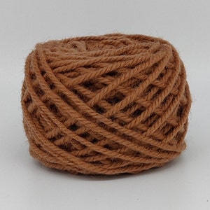 Peut inclure: Une pelote de laine brune, prête à être tricotée ou crochetée.