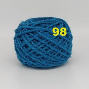 May include: A ball of teal yarn with the number 98 in yellow. The yarn is tightly wound, showing the texture of the fibers. The color is a vibrant, medium shade of blue-green, suitable for various knitting or crochet projects.
