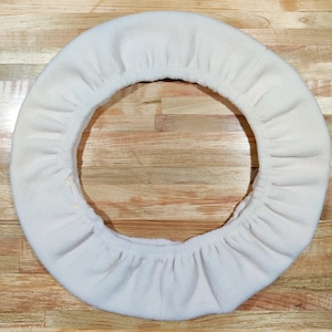 May include: White fleece steering wheel cover. The cover is made of soft, plush fabric and is designed to fit most standard steering wheels.