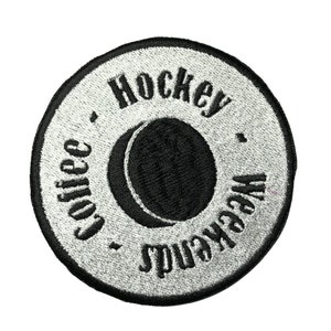 May include: A silver embroidered patch with a black hockey puck and the text "Hockey Weekend Coffee".