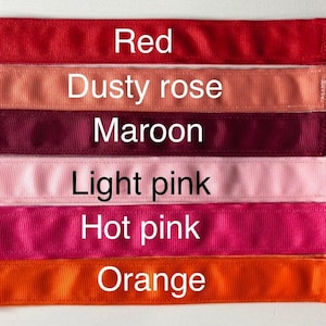 Six different colored ribbon samples, from top to bottom: red, dusty rose, maroon, light pink, hot pink, and orange.