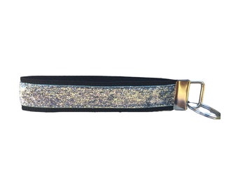 May include: Black key chain with a silver glitter stripe and a silver metal key ring.