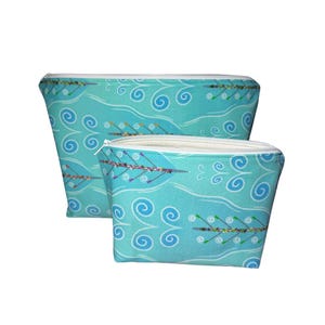May include: Two turquoise blue zippered pouches with a repeating pattern of white swirls. The pouches feature a graphic of rowers in a boat on a turquoise blue background.