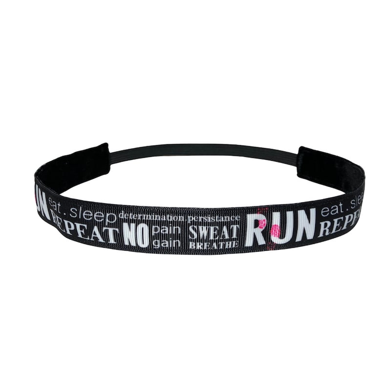 Black headband with white text that reads "RUN eat. sleep. determination. persistence. NO pain. SWEAT gain. BREATHE. REPEAT" with pink accents.