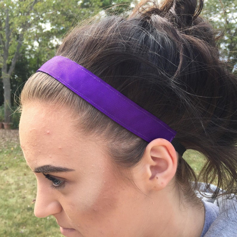 A purple headband made of grosgrain ribbon. The headband is worn by a person with dark hair.