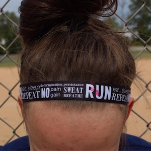 A black headband with white text that reads "eat, sleep, determination, persistence, repeat no pain, sweat gain, breathe run, eat, sleep, repeat".