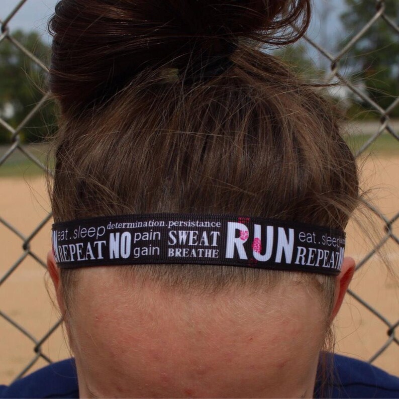 A black headband with white text that reads "eat, sleep, determination, persistence, repeat no pain, sweat gain, breathe run, eat, sleep, repeat".