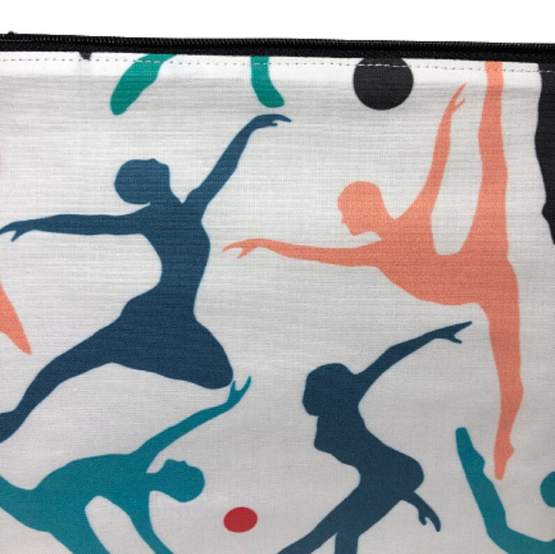 A white zippered pouch with a colorful pattern of dancers in various poses. The dancers are silhouetted in shades of blue, teal, pink, and orange.