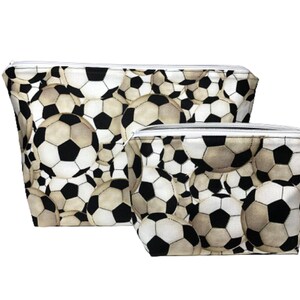 Two zippered pouches with a black and white soccer ball pattern. The larger pouch is in the background and the smaller pouch is in the foreground.