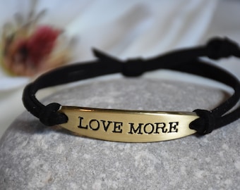 LOVE MORE Stamped Bracelet: Gold Metal Charm, Adjustable Faux Suede Cord