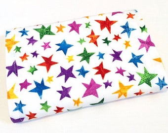 May include: A white fabric with a colorful star pattern. The stars are in various shades of red, orange, yellow, green, blue, purple, and pink.
