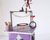 Papier mache circus box. Masked Dog sculpture tightrope walker with unicycle, trampoline, juggling bats. Mixed media sculpture